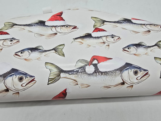 Fish patterned paper with fish wearing Santa hats on a white background